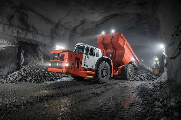 An underground electric dumper powered by batteries Underground scene featuring an electric battery-powered dumper actively transporting loads in a mining operation.